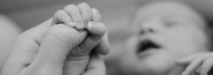 This is an image of a baby and a mother's hand in a blog post on Mama Energy by Haripriya Suraj, Reiki Master